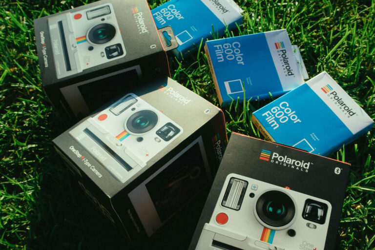 Polaroid Film & Camera - displayed on green grass background