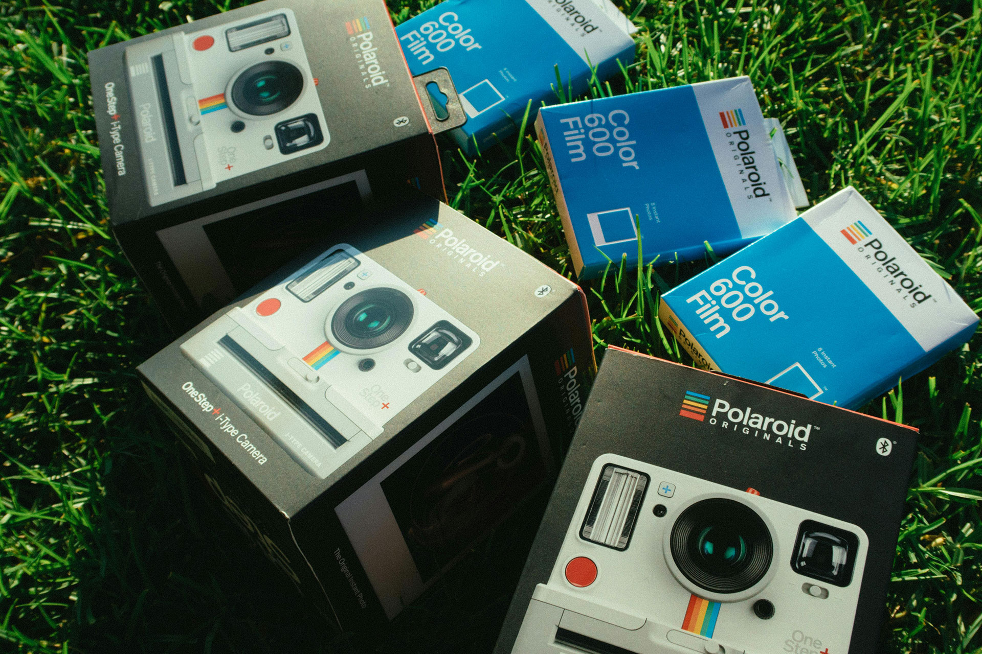 Polaroid Film & Camera - displayed on green grass background
