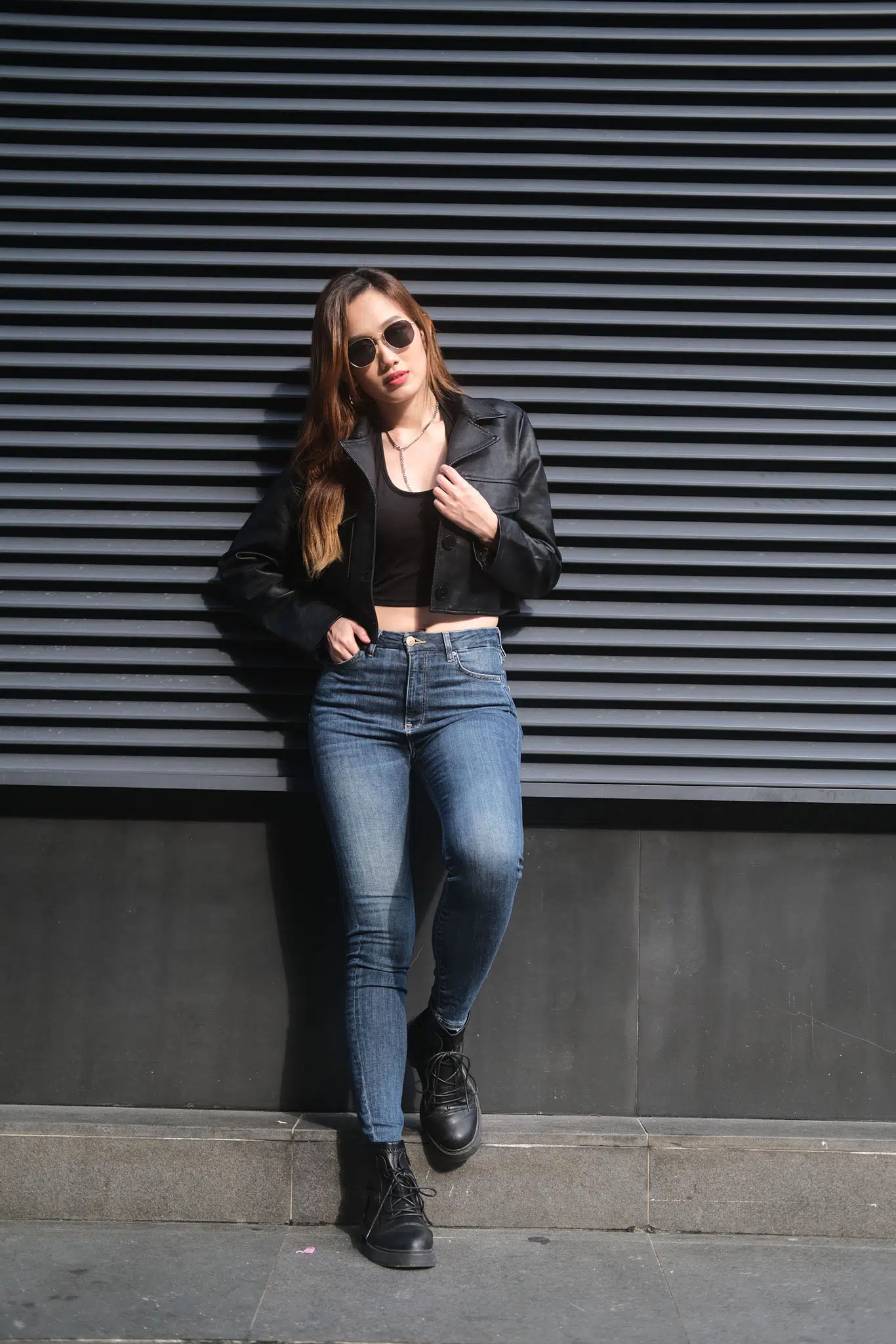 Woman standing at a slight angle, weight on one leg, head tilted gently, arms relaxed—shows a casual, natural pose for female portraits