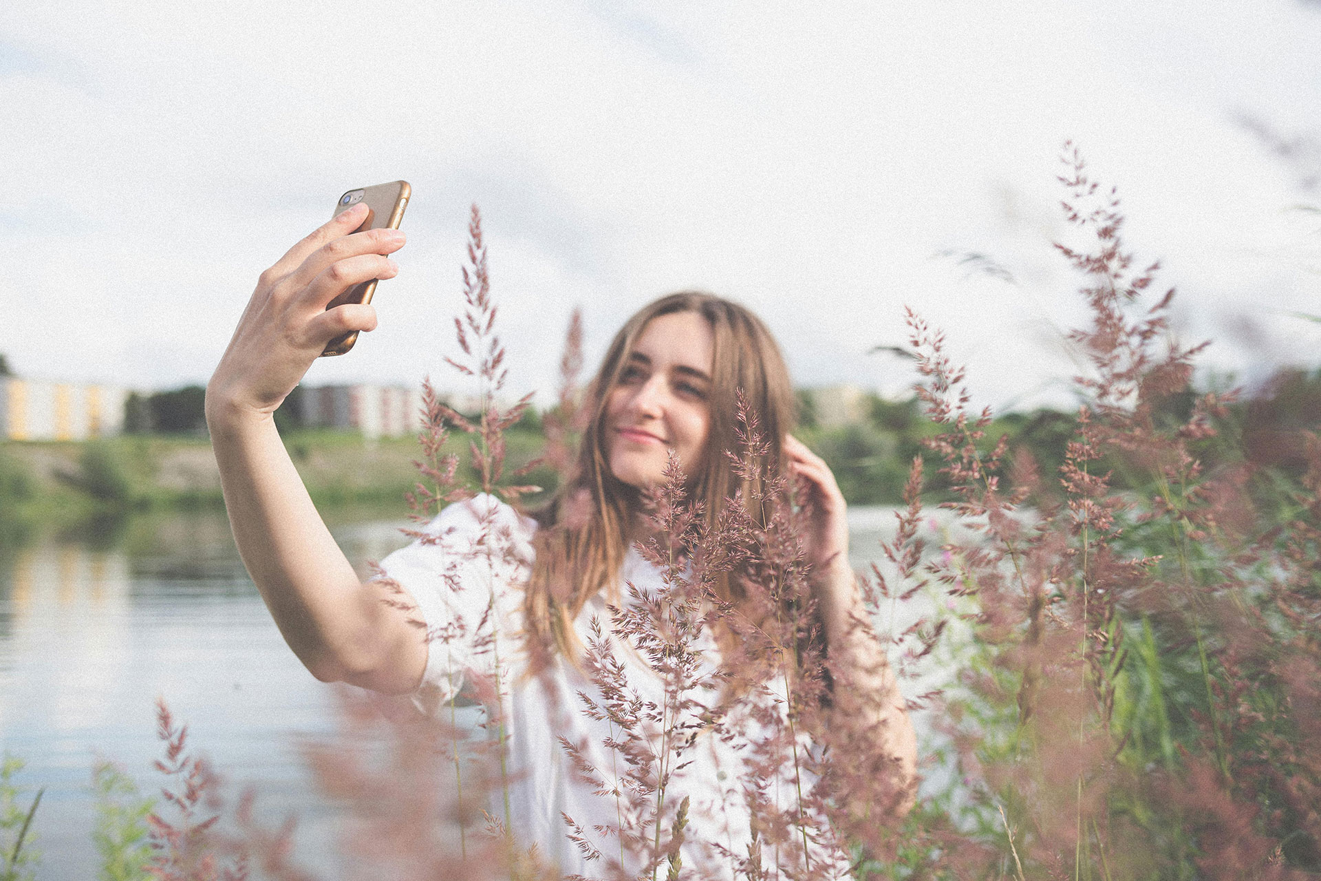 Best Poses For Selfie - Raise one hand above your head to touch your hair, and slightly tilt your head to open up your frame