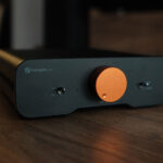 Front view of the Fosi Audio ZA3 stereo amplifier showing the power switch, volume control knob, and minimalist aluminum design